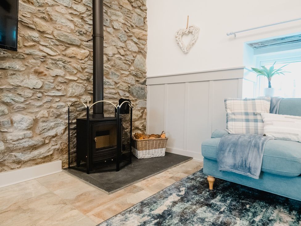 A living room with a fireplace and sofa at The Old Barn in Manchester
