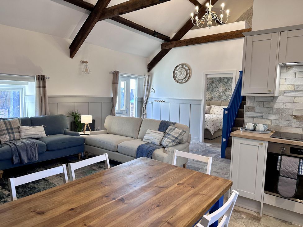 A living room with sofas and a dining table at The Old Barn in Manchester