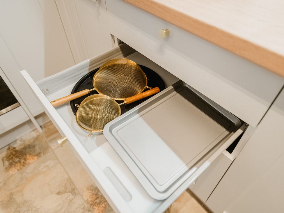 A kitchen drawer containing a baking tray and two sieves at The Old Barn in Manchester