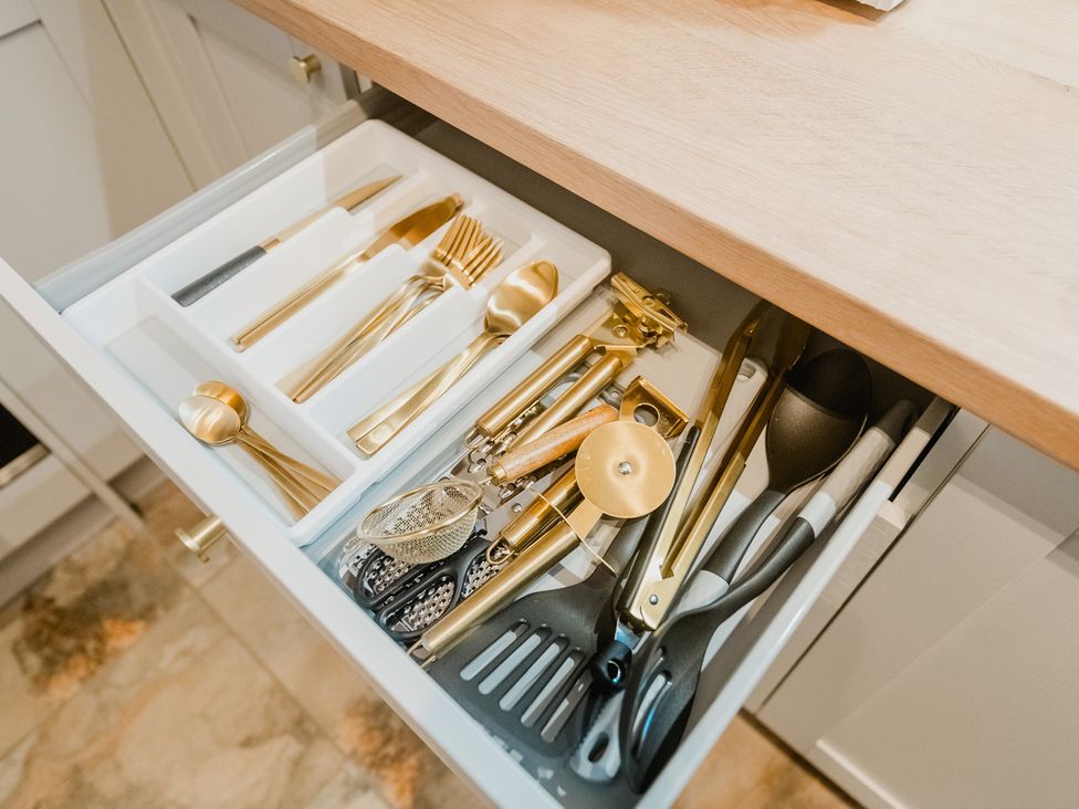 A drawer containing cutlery and kitchen tools at a kitchen