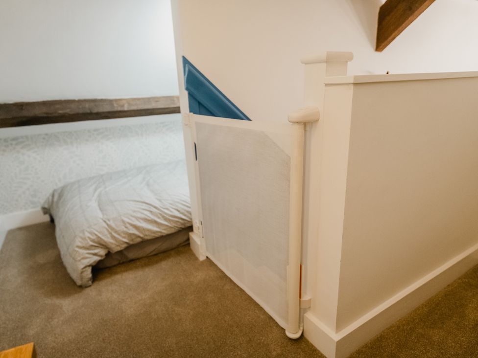 A bedroom with a bed and a baby gate at The Old Barn in Manchester