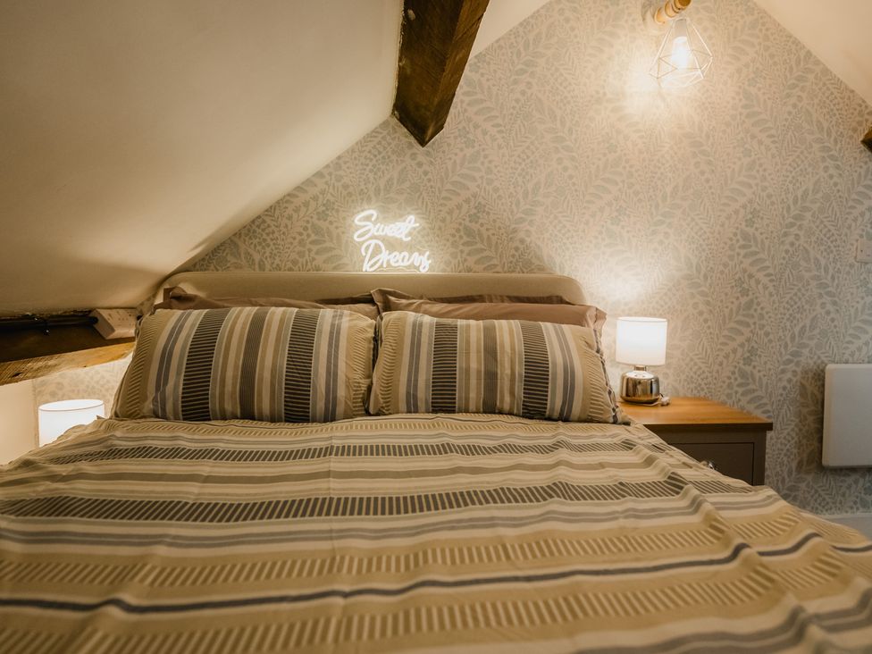 A bedroom with a bed and bedside table at 