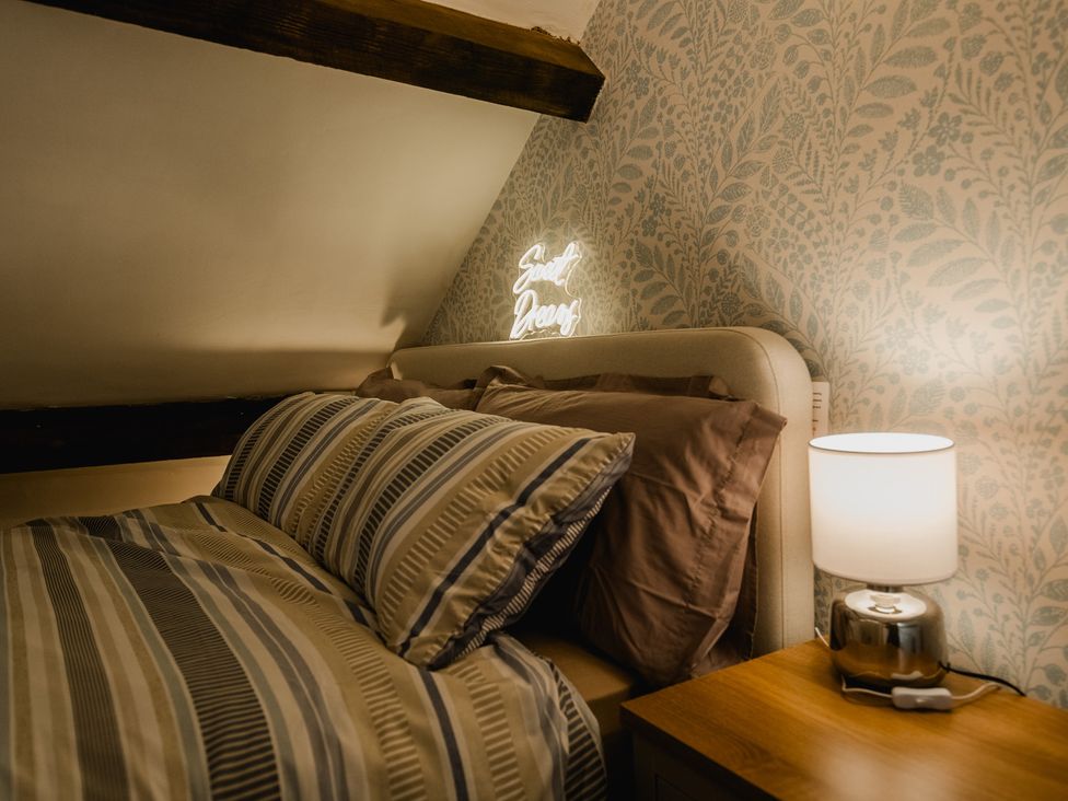 A bedroom with a bed and bedside lamp at The Old Barn in Manchester