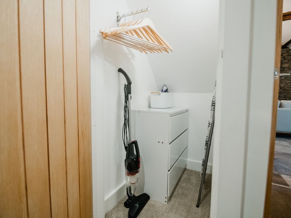 A closet with a vacuum cleaner and storage unit at 