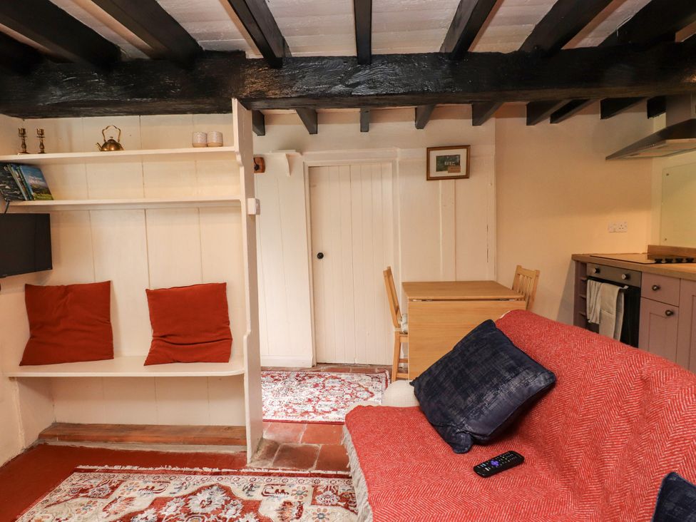 A living room with a sofa, table, and chairs at Felin Bach in Aberdaron