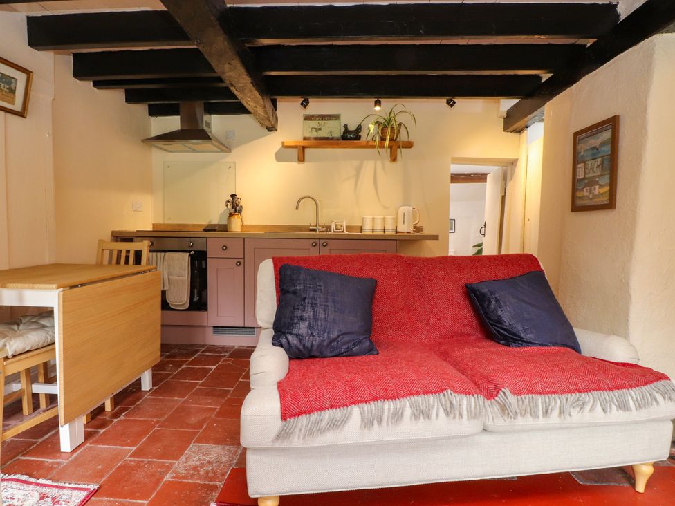 A kitchen with a sofa and dining table at Felin Bach in Aberdaron
