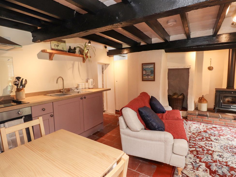 A kitchen with sink, stove, and sofa at Felin Bach in Aberdaron
