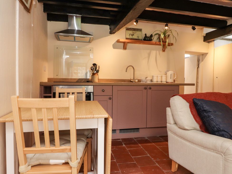 A kitchen with cabinets and a table at Felin Bach in Aberdaron