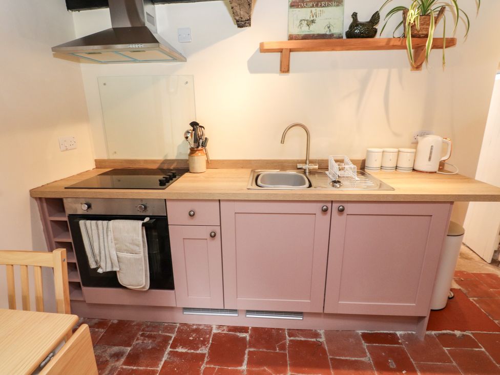A kitchen with a stove and sink at Felin Bach in Aberdaron