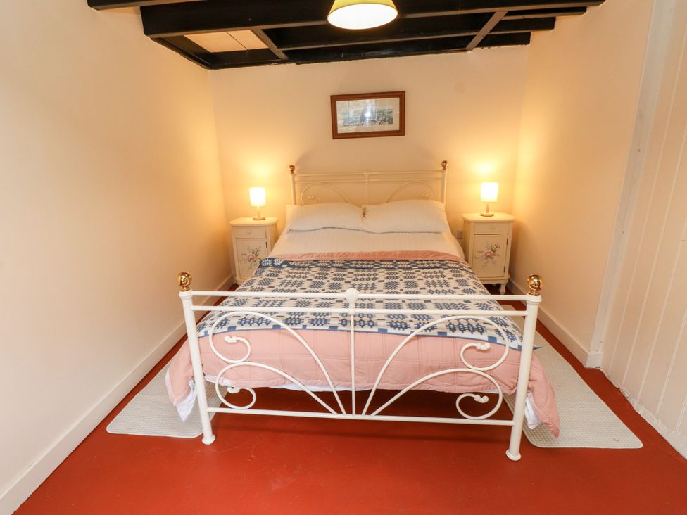 A bedroom with a bed and bedside tables at Felin Bach Aberdaron