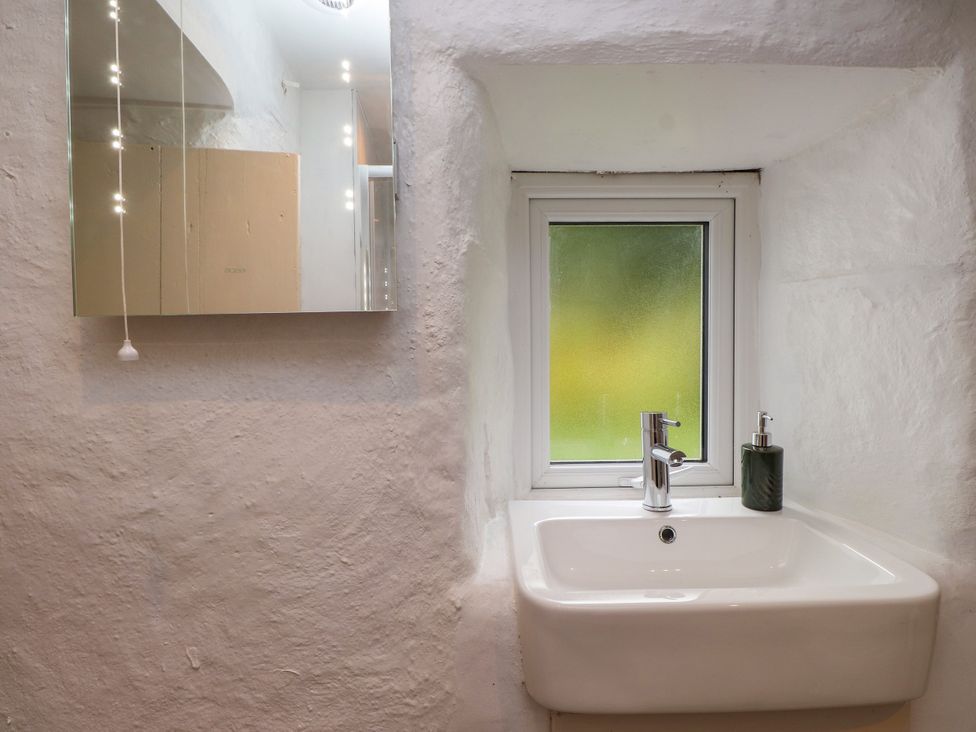 A bathroom with a sink and a window at Felin Bach Aberdaron