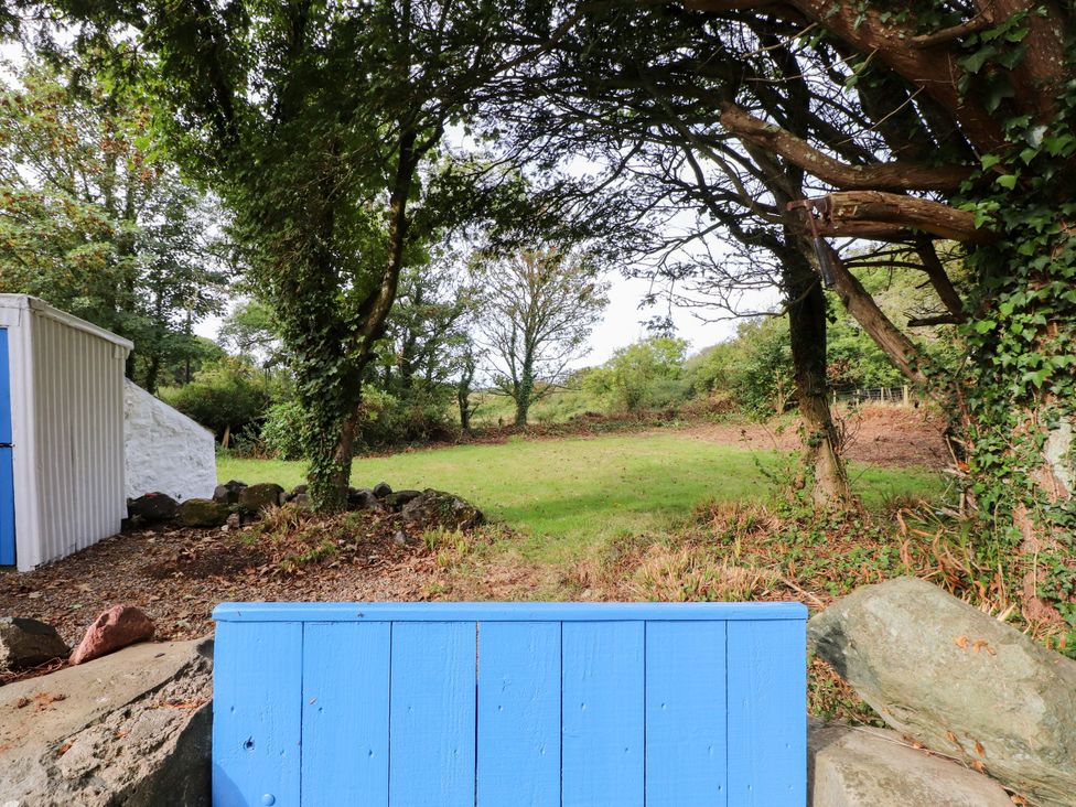 A garden with trees and a shed at Felin Bach in Aberdaron