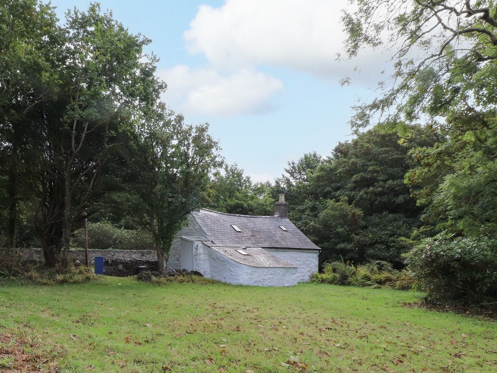 A house surrounded by trees and grass at Felin Bach Aberdaron
