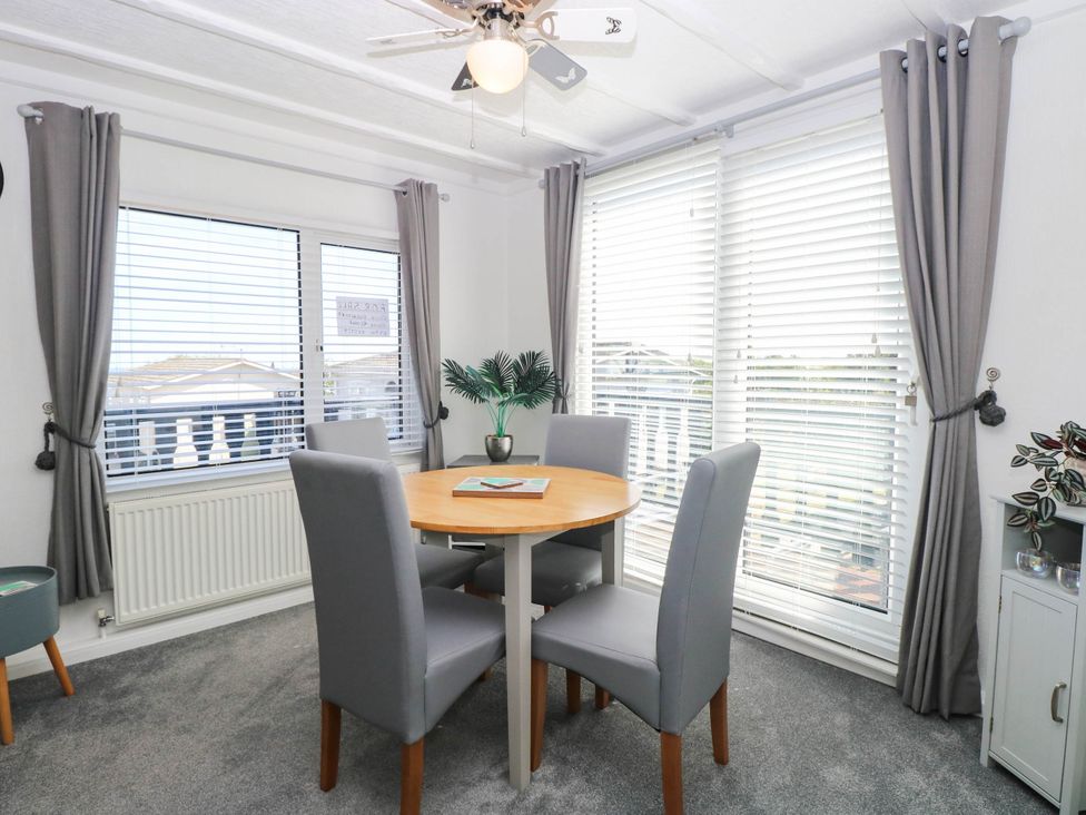A dining room with a table and chairs at Sea Mist in Trimingham
