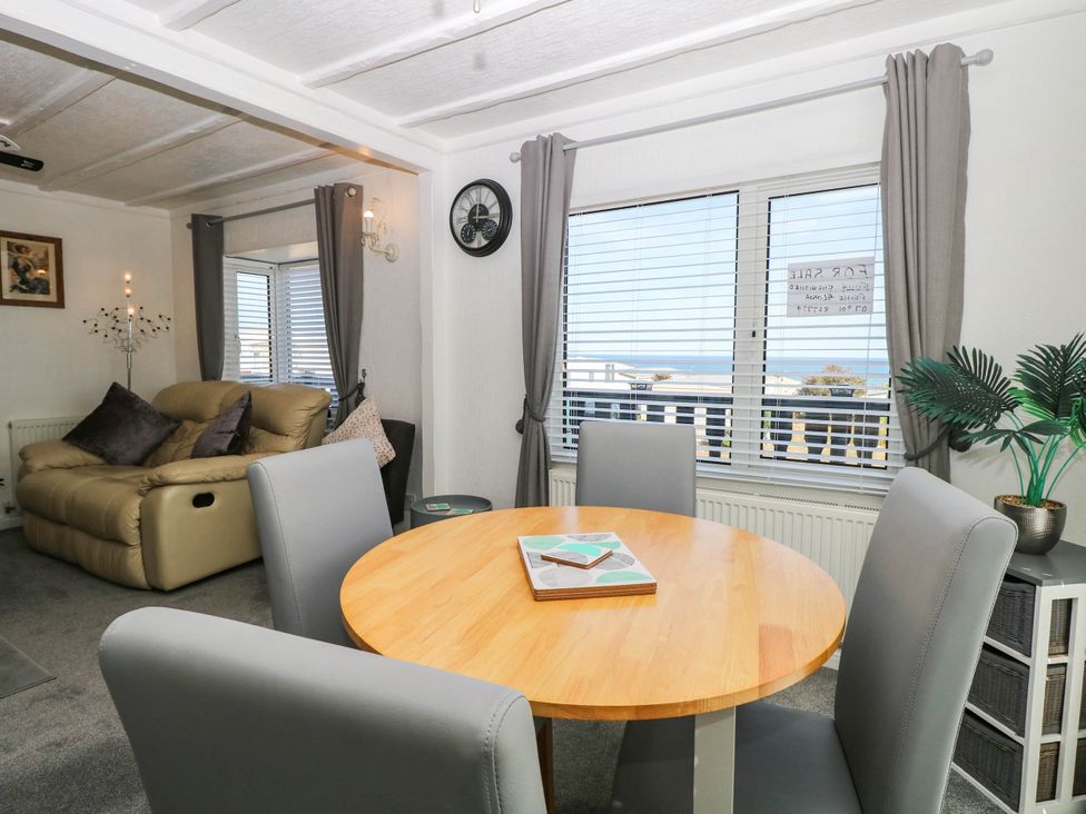 A dining room with a table and chairs at Sea Mist in Trimingham