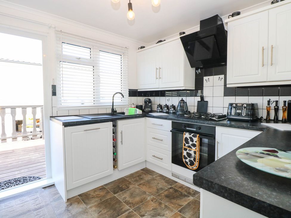 A kitchen with appliances and cabinets at Sea Mist in Trimingham