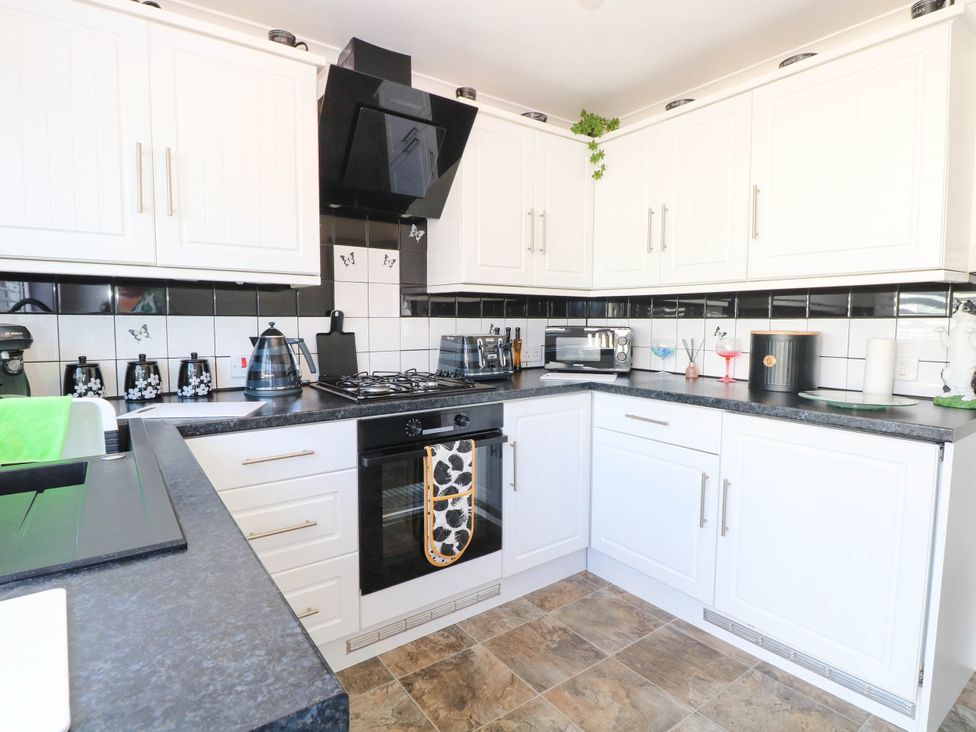 A kitchen with stove and cabinets at Sea Mist in Trimingham
