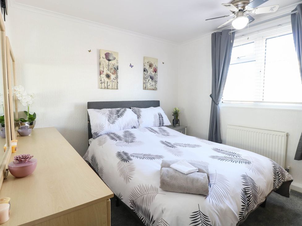 A bedroom with a bed and mirror at Sea Mist in Trimingham