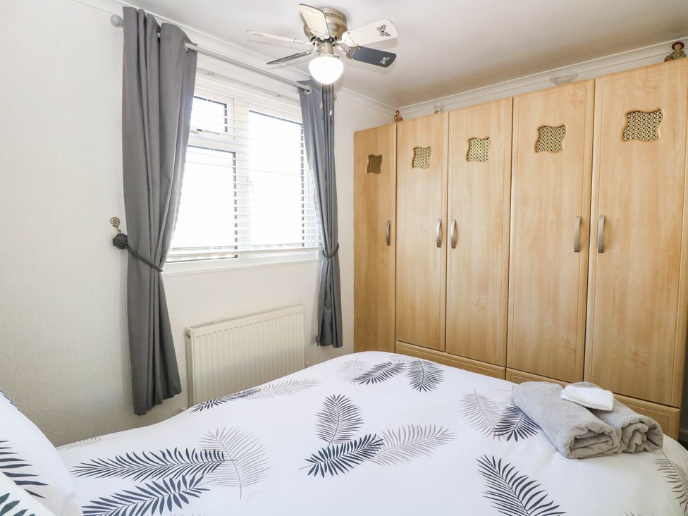 A bedroom with a bed and wardrobe at Sea Mist in Trimingham