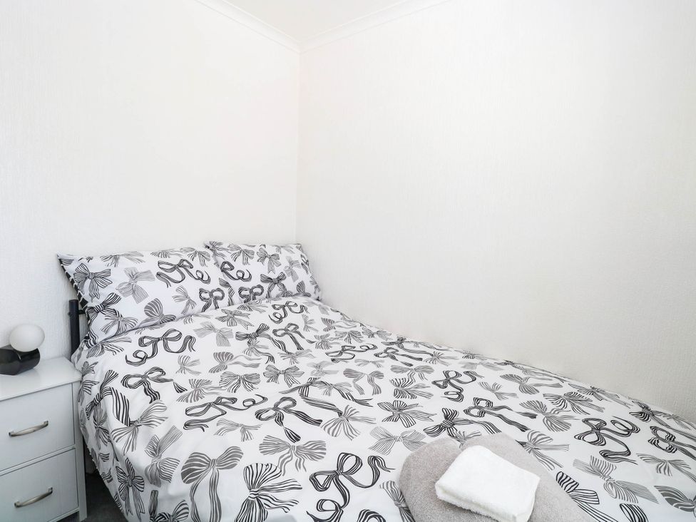 A bedroom with a bed and bedside table at Sea Mist in Trimingham
