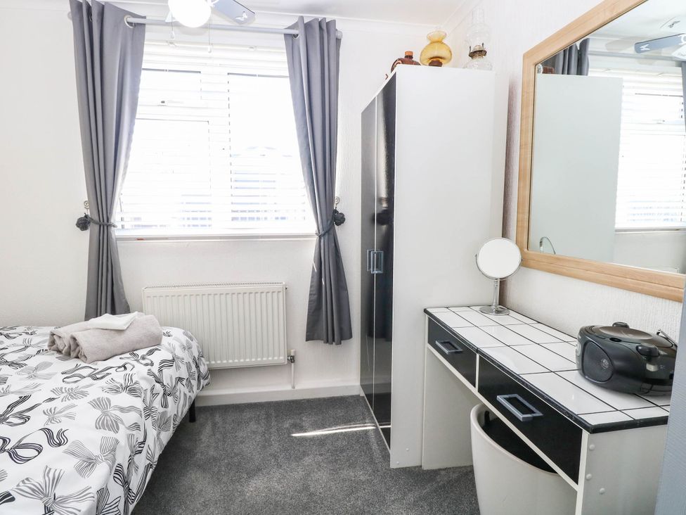 A bedroom with a bed and a wardrobe at Sea Mist in Trimingham