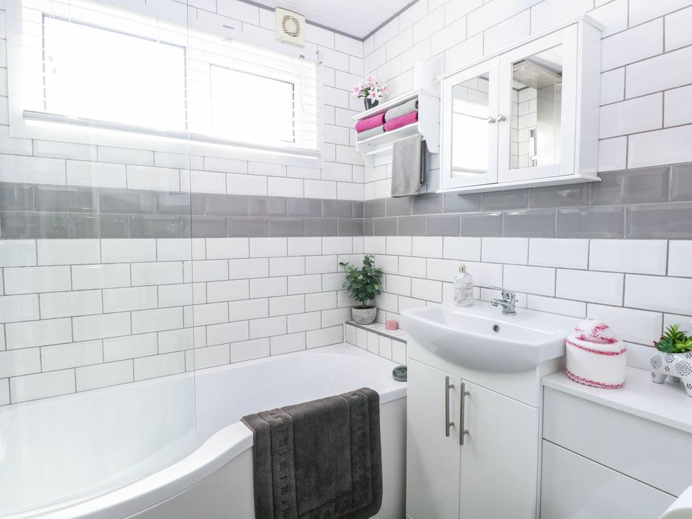 A bathroom with a bathtub and sink at Sea Mist in Trimingham