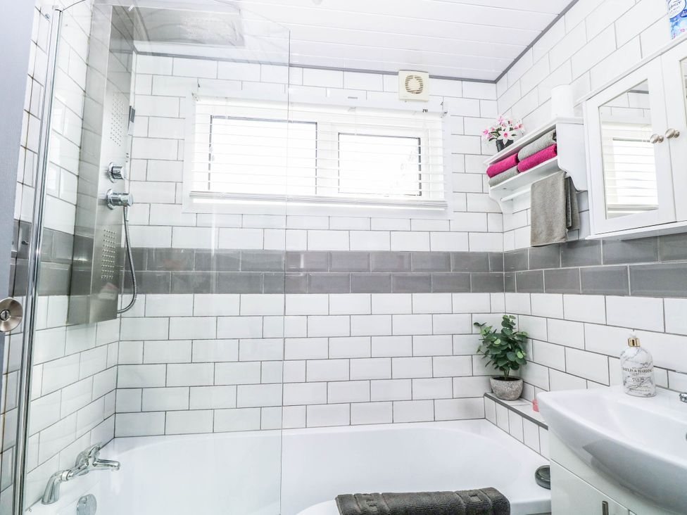 A bathroom with a shower and bathtub at Sea Mist in Trimingham