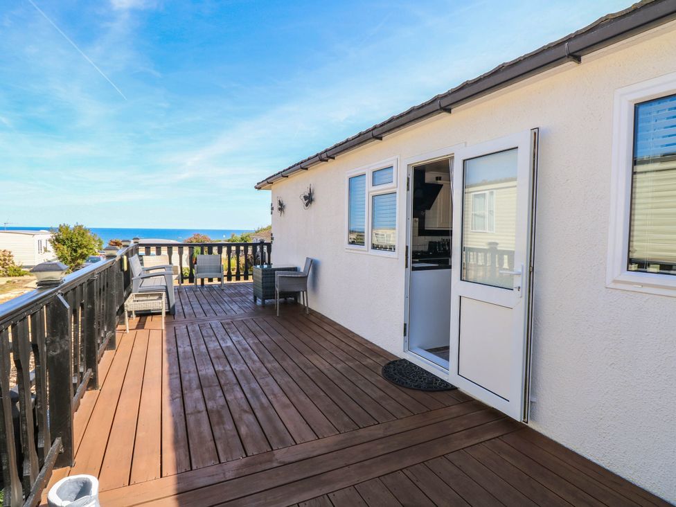 An outdoor area with a deck and chairs at Sea Mist in Trimingham