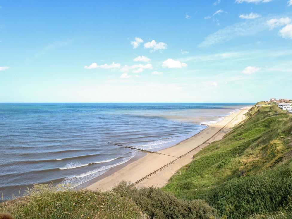 A beach with sand and cliffs at Sea Mist in Trimingham