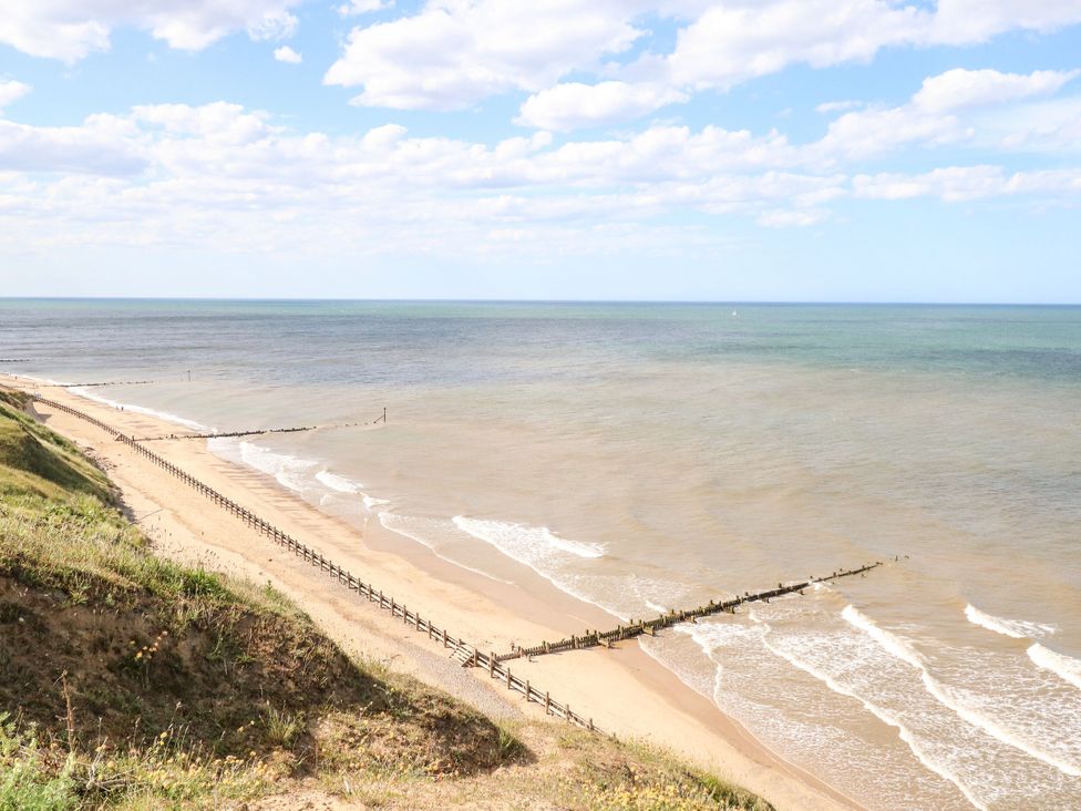A beach with wooden groynes and waves at Sea Mist in Trimingham