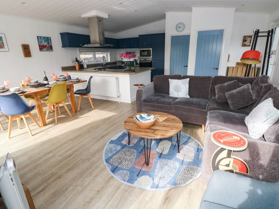 A living room with a sofa, coffee table, and dining area at Pleasant Valley Holiday Lodge 70 in Stepaside