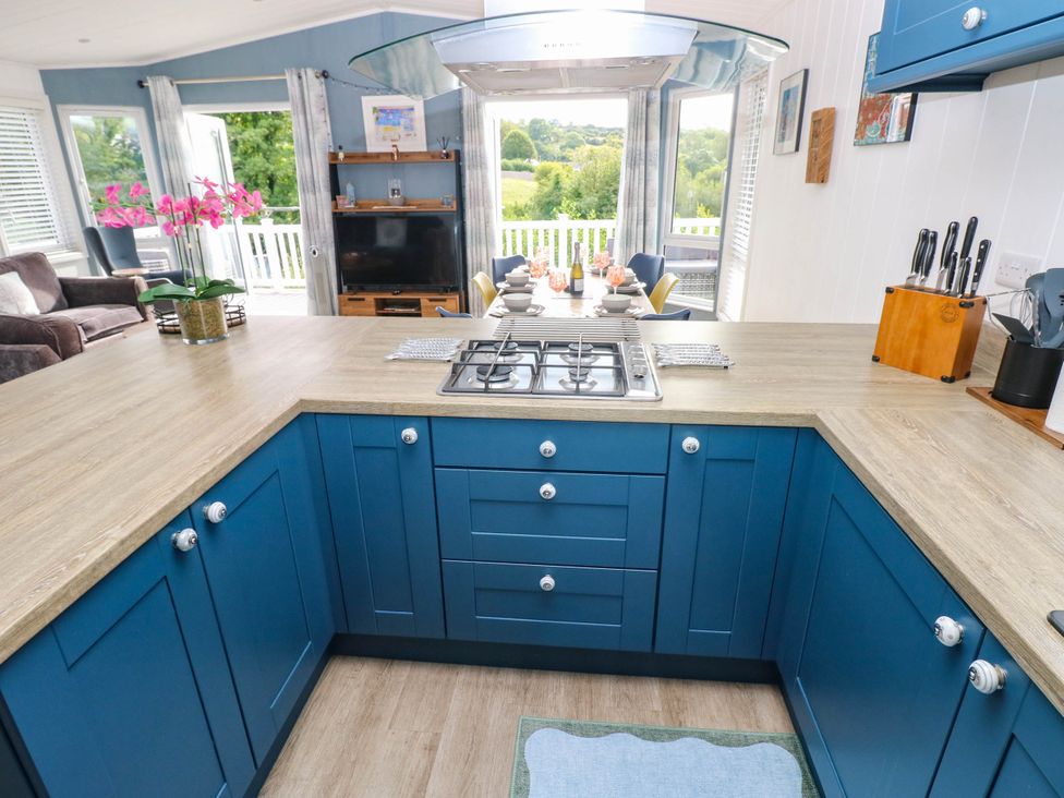 A kitchen with a stove and table at Pleasant Valley Holiday Lodge 70 Stepaside