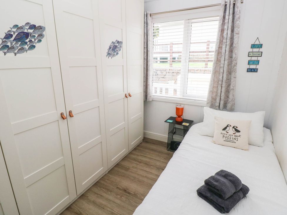 A bedroom with a bed and wardrobe at Pleasant Valley Holiday Lodge 70, Stepaside