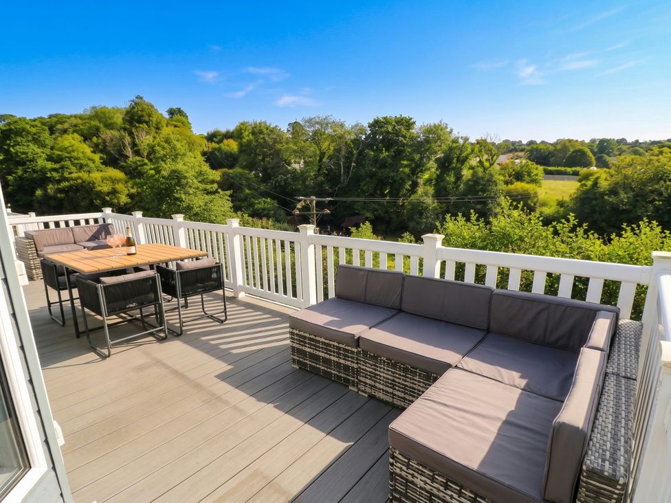 An outdoor deck with seating and dining table at Pleasant Valley Holiday Lodge 70 Stepaside