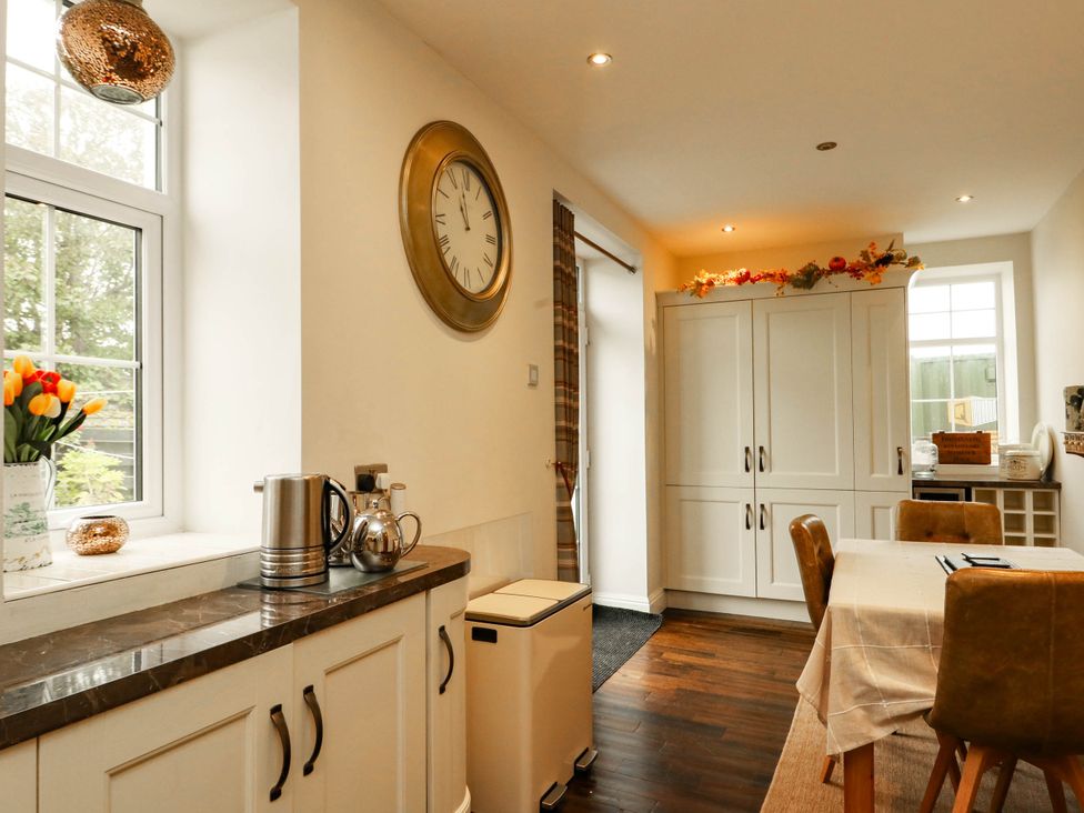 A kitchen with a table and chairs at 11 Bryn Goleu Avenue North in Holyhead