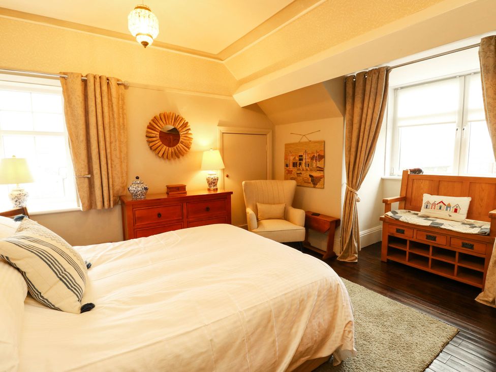 A bedroom with a bed and an armchair at 11 Bryn Goleu Avenue North Holyhead