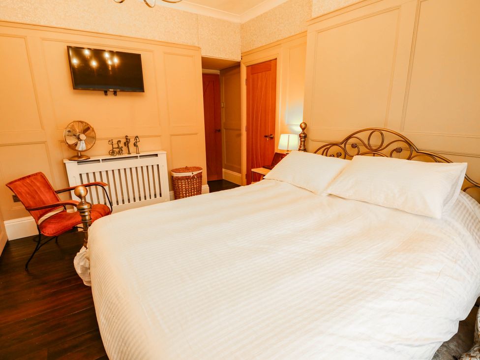 A bedroom with a bed and a chair at 11 Bryn Goleu Avenue North in Holyhead
