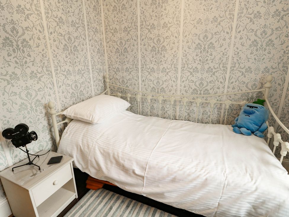 A bedroom with a bed and nightstand at 11 Bryn Goleu Avenue North in Holyhead