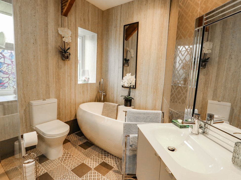 A bathroom with a bathtub, sink, and toilet at 11 Bryn Goleu Avenue North Holyhead