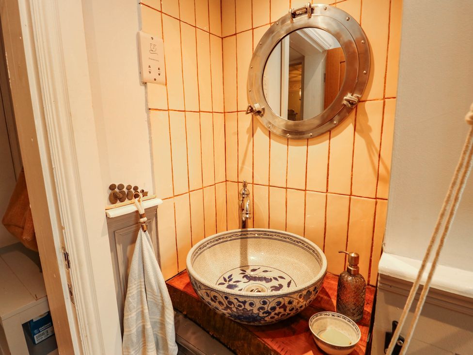 A bathroom with a decorative sink and mirror at 11 Bryn Goleu Avenue North Holyhead