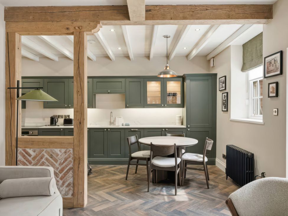 A kitchen with cabinets and dining table at Apt. 2 in York