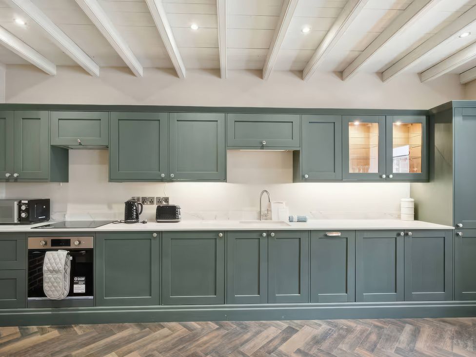 A kitchen with cabinets, microwave, kettle, and sink at Apt. 2 in York