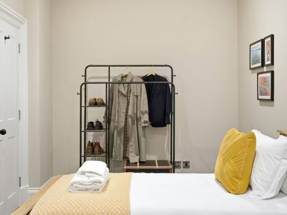 A bedroom with a bed and a clothing rack at Apt. 2 in York