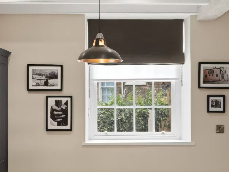 A wall with photographs and a lamp above the window at Apt. 2 in York
