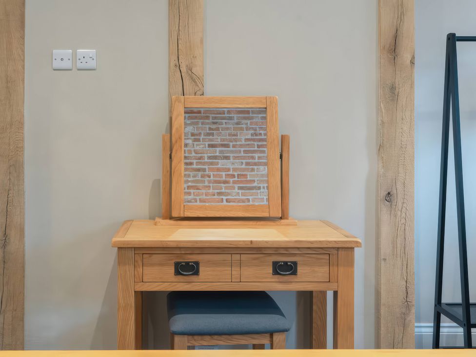 A desk with a mirror and a chair at Apt. 2 in York