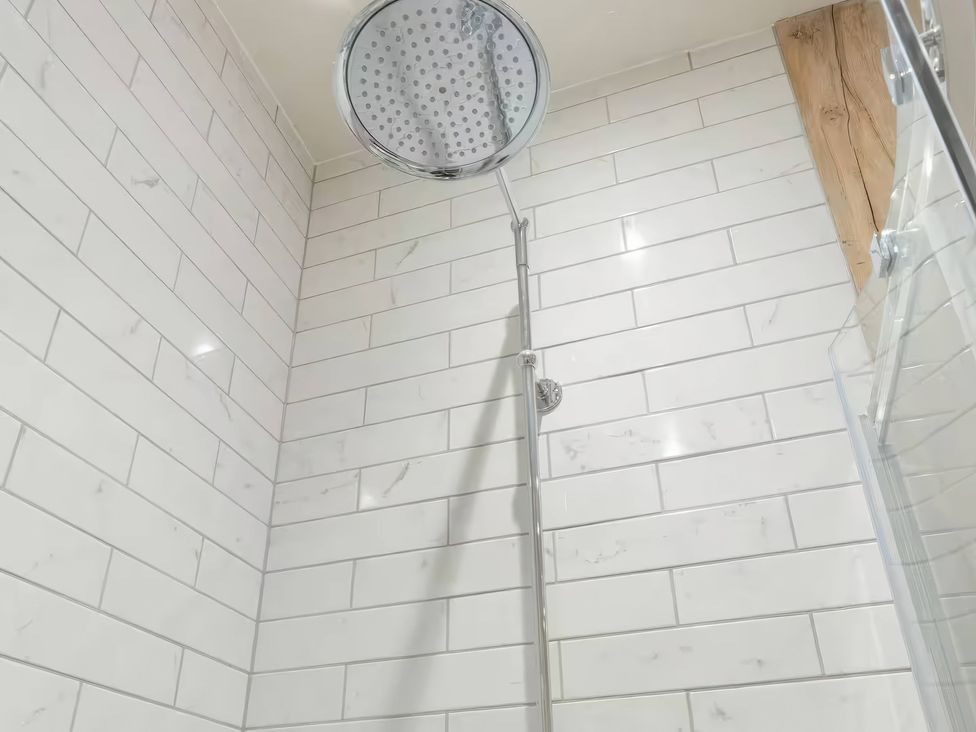 A shower with a rain shower head and tiled walls at Apt. 2 in York