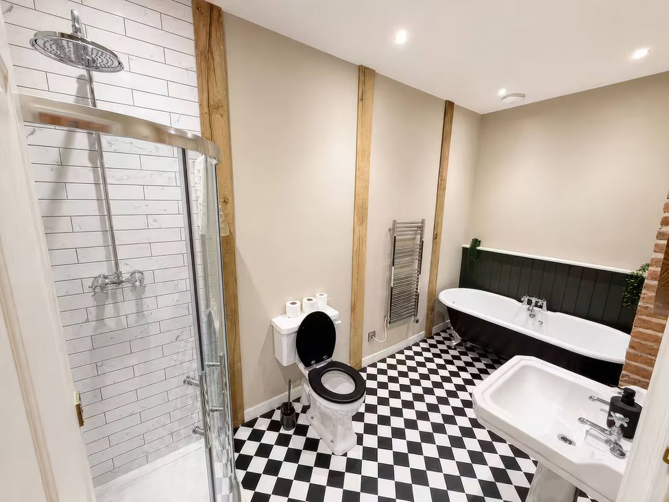 A bathroom with a shower, toilet, bath tub, and sink at Apt. 2 in York