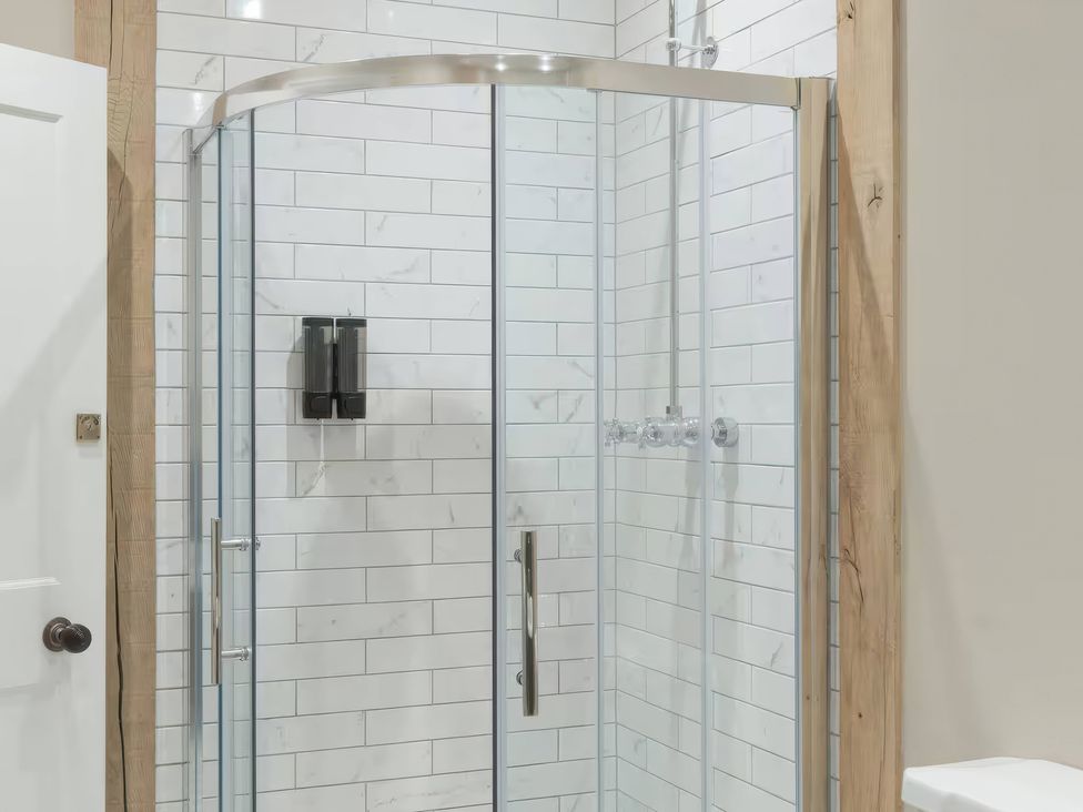 A shower with glass door and tiled walls at Apt. 2 in York