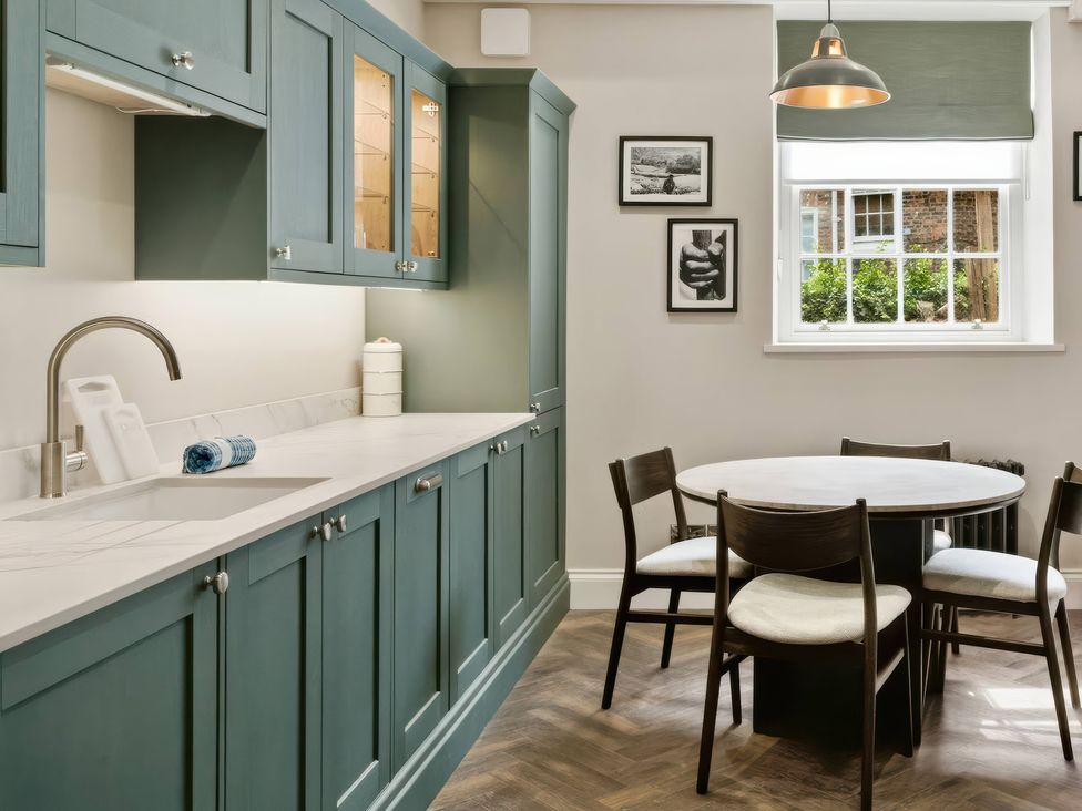 A kitchen with cabinets and dining table at Apt. 2 in York