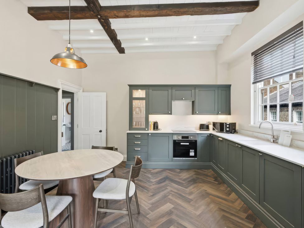 A kitchen with cabinets and a dining table at Apt. 3 in York
